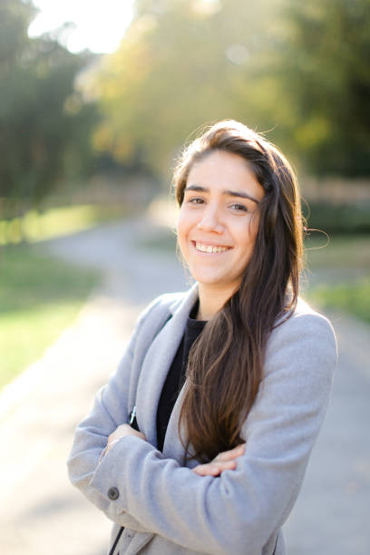 istock Young smiling woman wearing coat standing outside 1182793948