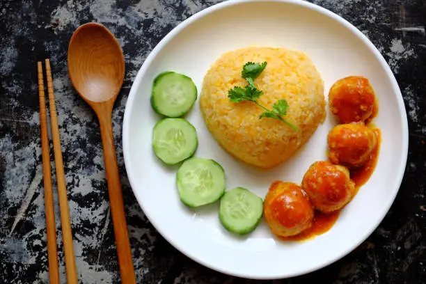 Top view Vietnamese vegan rice dish with meatballs from tofu ball with tomato sauce, cucumber for vegetarian lunch meal, homemade delicious and safe, healthy food from Vegetal diet