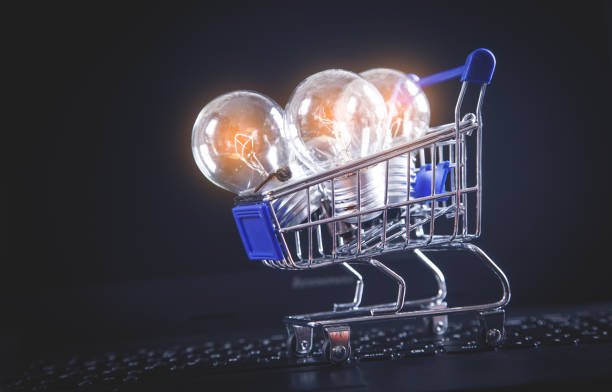 istock Light bulbs with shopping cart on computer keyboard. 1182798230