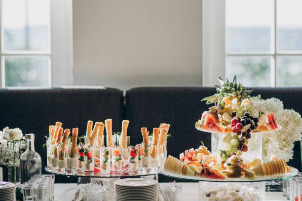istock Delicious italian food table at wedding reception. Tomatoes, basil,cheese,prosciutto, greenery, bread, and fruits appetizers on table at wedding or christmas feast. Luxury catering concept 1182798855
