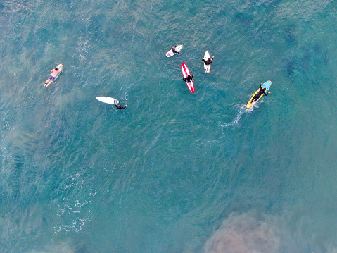 Aerial top view of surfers waiting the waves in blue water. Del Mar Beach, California, USA