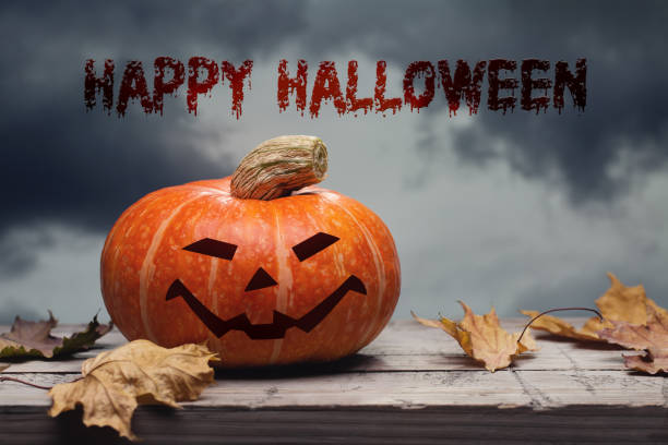 istock One pumpkin on an old table with autumn leaves. Evening sky with gloomy clouds. Copy space, halloween design. 1182799791