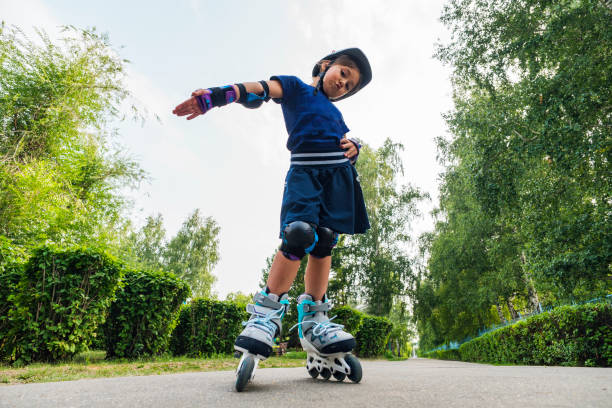 child on inline skates in park. kids learn to skate roller blades. little girl skating on sunny summer day. outdoor activity for children on safe residential street. active sport for preschool kid. - roller skate imagens e fotografias de stock