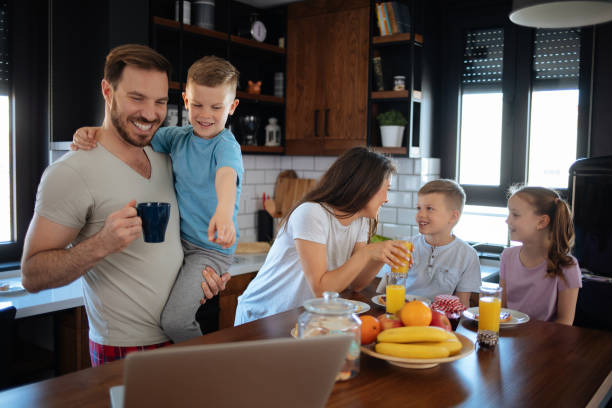 istock Father using laptop with son, family in background 1182803959