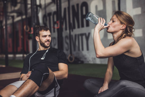 istock Young athletic couple resting on a break in a gym. 1182803998