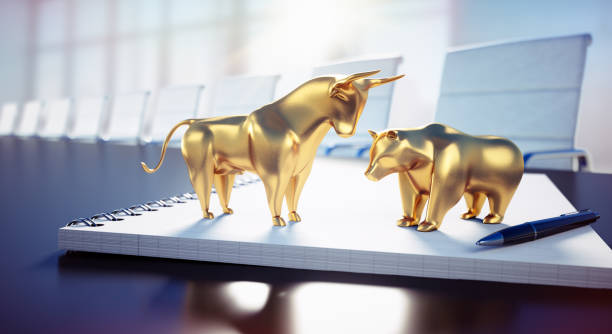 golden bull und bär auf notebook - businessbear stock-fotos und bilder