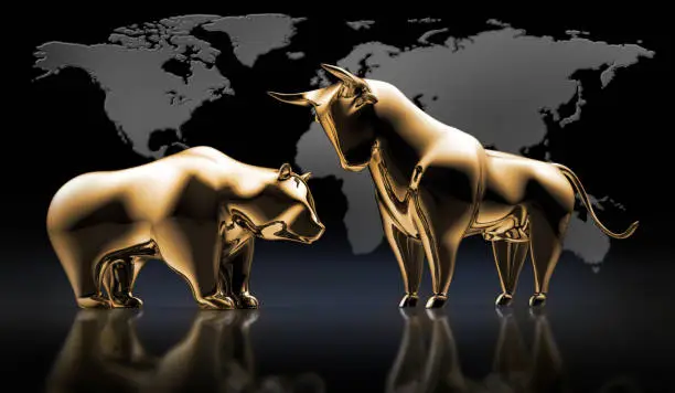 Golden Bull and Bear standing in Front of a dark grey World Map