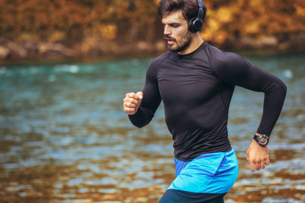 istock Handsome young man jogging on river bank 1182812510