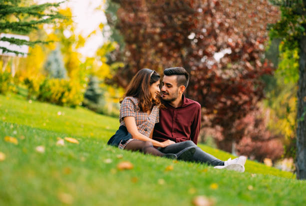 istock Young Couple Sitting on the Grass 1182813766