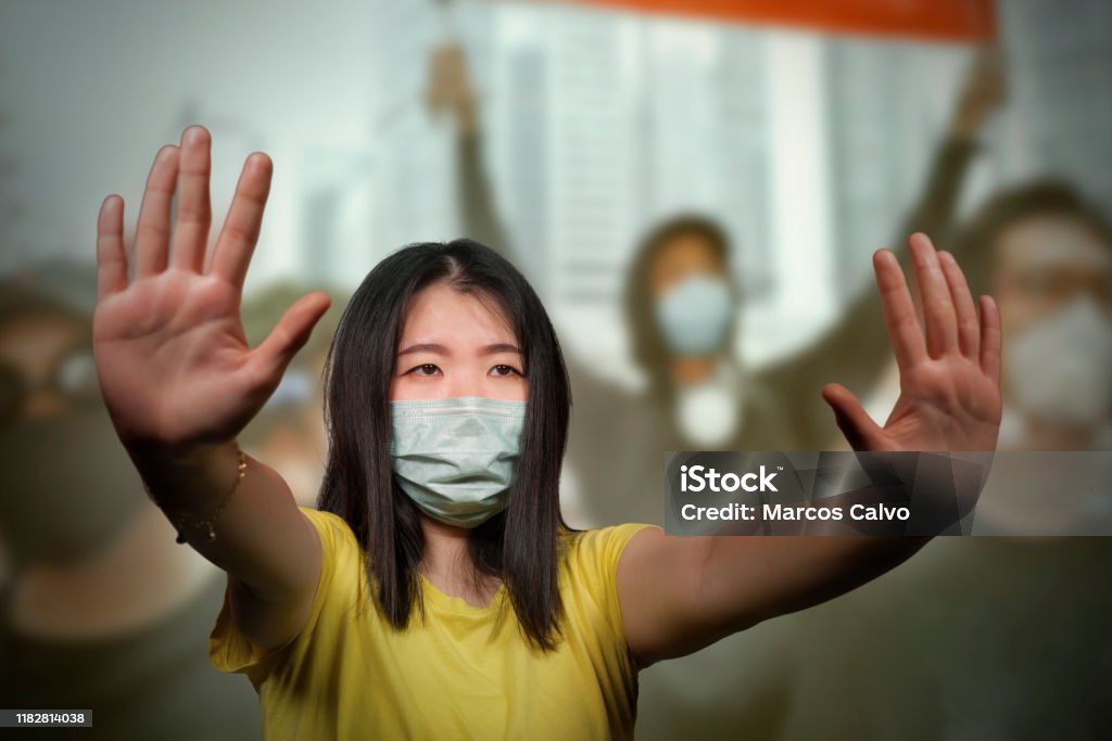 young beautiful pacifist Asian woman angry and outraged protesting on street demonstration against China abuse standing for freedom and human rights showing clean hands as symbol of peace Protest Stock Photo