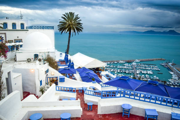 Terrace Balconies of Historic Sidi Bou Said, Harbour, and Mediterranean Sea under a stormy sky - Tunis, Tunisia