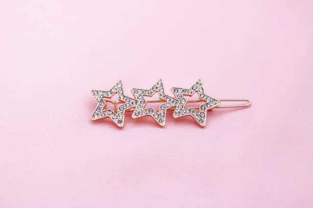Luxury star shape hair clip on pink fabric with copyspace.