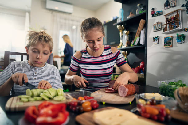 istock Brother and sister making sandwiches 1182816808