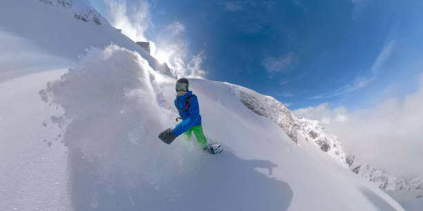 istock VR360: Cool snowboarder dude shredding untouched snow high in the mountains. 1182817094