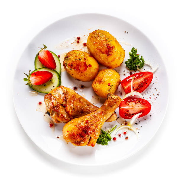 istock Roast chicken drumsticks with fried potatoes and vegetables 1182817521