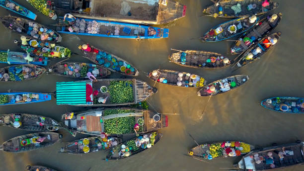 aerial: местные жители покупают и продают красочные продукты из деревянных лодок. - меконг реки стоковые фото и изображения