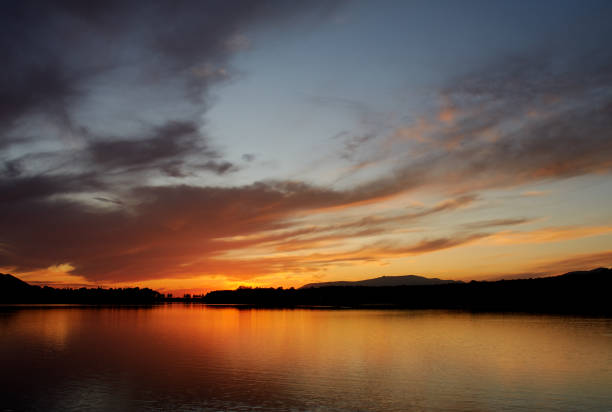 istock Nice sunset on a lake with lots of clouds 1182820451