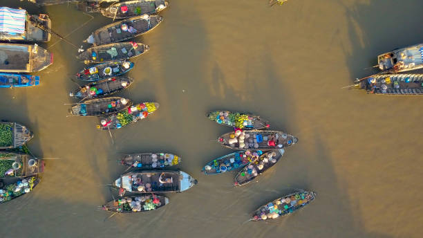 istock AERIAL: Flying above a bustling floating market on murky river on sunny evening. 1182820760