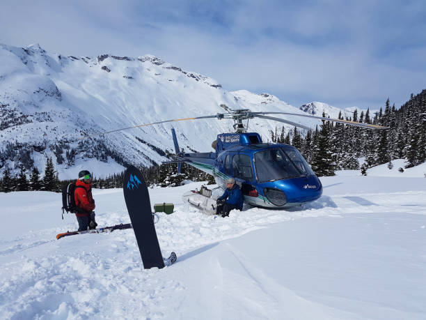 극단적 인 스노우 보더와 산에 주차 된 파란색 헬리콥터에 의해 파일럿 이야기. - skiing powder snow canada winter 뉴스 사진 이미지