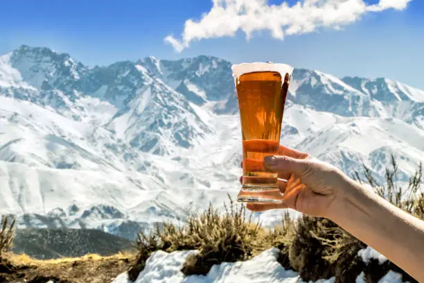 Photo of Tasty and fresh red beer at the foot of the snowy mountain.