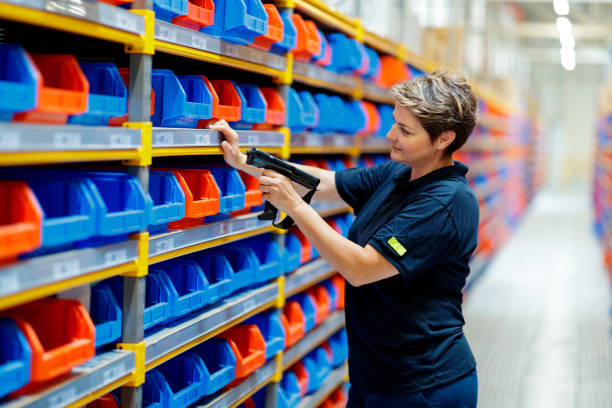 Woman checking barcodes in warehouse Female warehouse worker checking barcodes in warehouse filing tray stock pictures, royalty-free photos & images