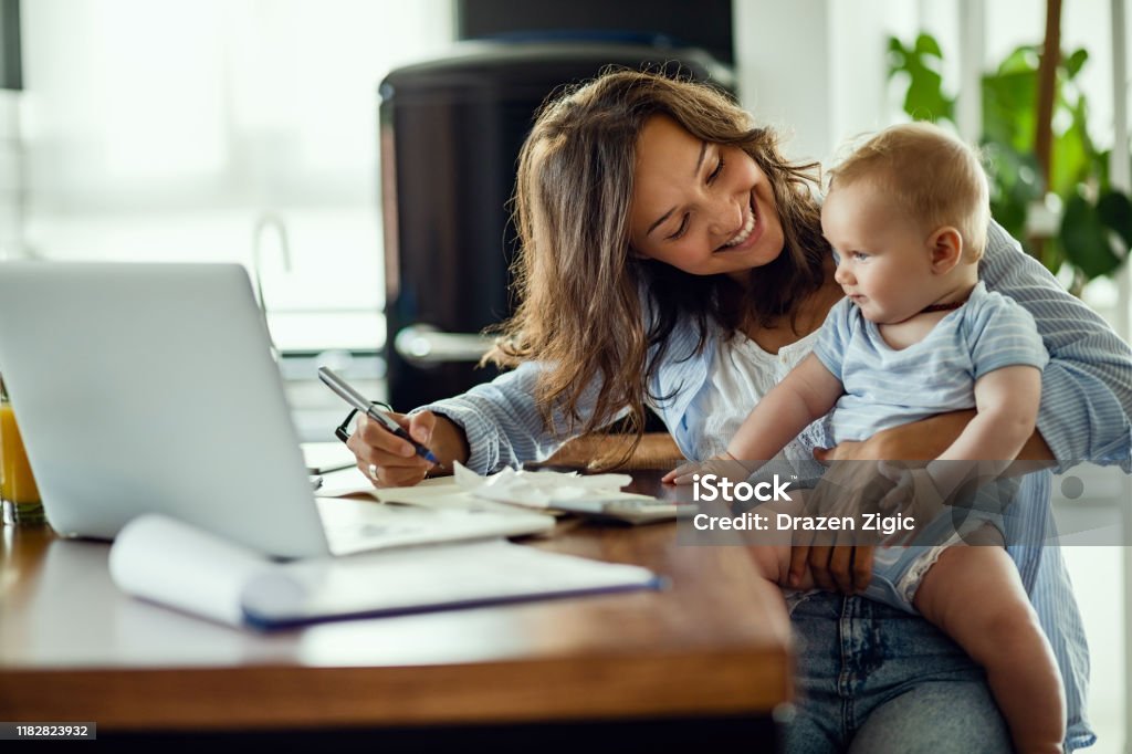 Glückliche Mutter spricht mit ihrem Baby während der Arbeit zu Hause. - Lizenzfrei Mutter Stock-Foto