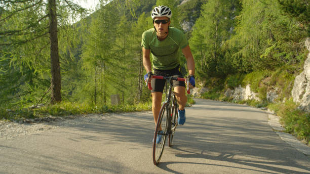 istock SLOW MOTION: Athletic Caucasian man pedalling his road bicycle up a steep hill. 1182825190