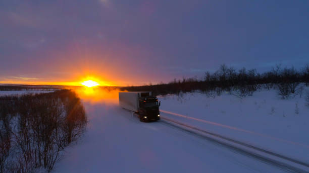 istock LENS FLARE: Large truck speeding down empty road through the wintry landscape. 1182825756