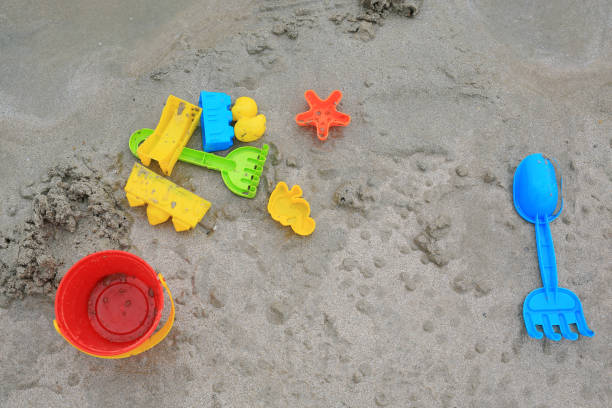 istock Children's Toys on sand beach background. 1182827152