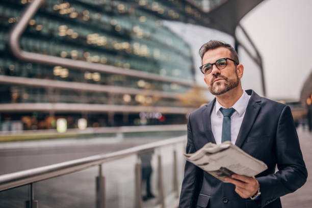 istock Gentleman in suit reading newspaper 1182827840