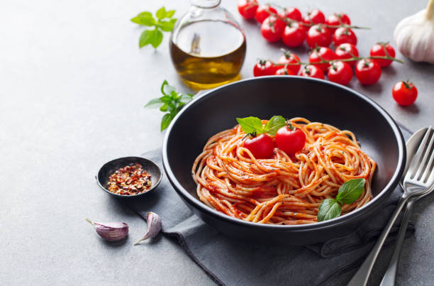 istock Pasta, spaghetti with tomato sauce in black bowl on grey background. Copy space. 1182828063