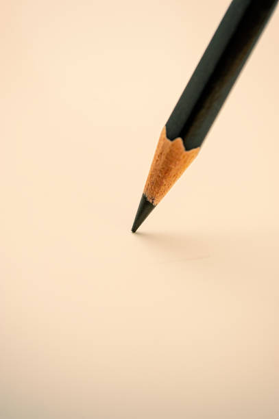 istock single black pencil lies on a light background, close-up. 1182828681