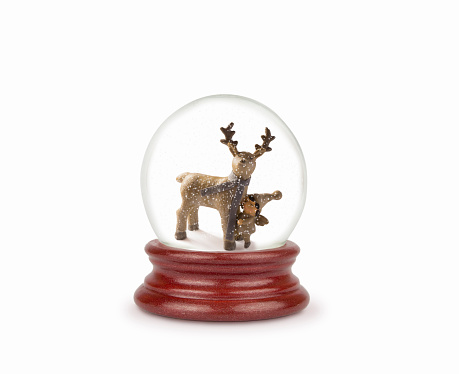 Christmas snow globe isolated on white. Can be used as a Christmas or a New Year gift or symbol. Christmas and New Year design element. Toy glass snow globe with deer and baby. Snow ball on white.