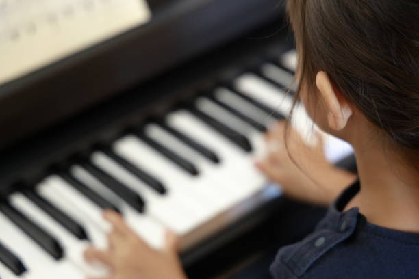 ragazza giapponese che suona un pianoforte (4 anni) - toddler music asian ethnicity child foto e immagini stock