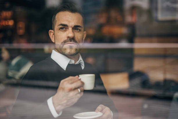 istock Handsome gentleman drinking coffee in cafe 1182829661