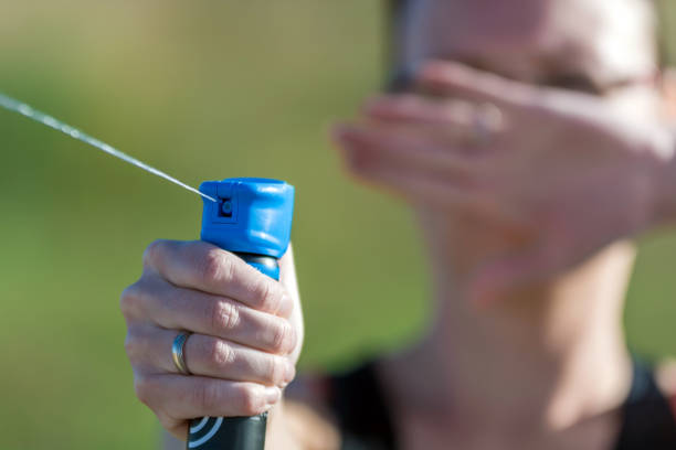 mujer se defiende con spray de pimienta contra el atacante - pulverizador de pimienta fotografías e imágenes de stock