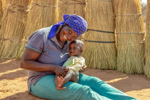 African woman in the village holding her child in the lap,