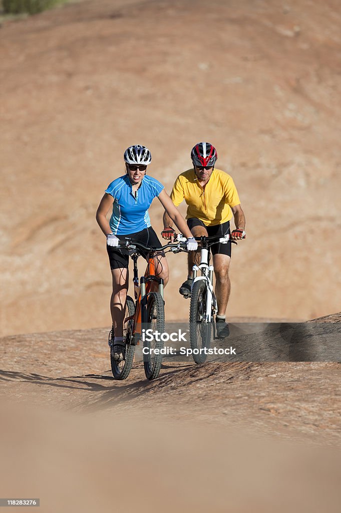 Jeune Couple Riding Mountain Bikes sur les Dunes de sable pétrifiée - Photo de Activité de loisirs libre de droits