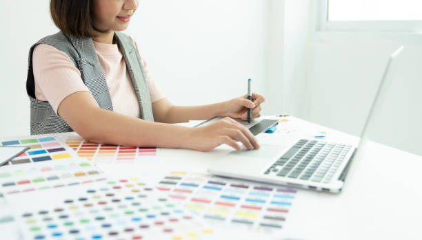 istock Graphic designer at work. Color swatch samples. Artist drawing something on graphic tablet at the office. Graphic designer creativity editor ideas designer concept 1182833431