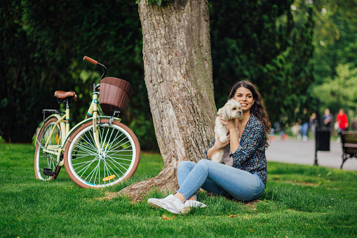 Young pretty woman enjoying picnic with dog