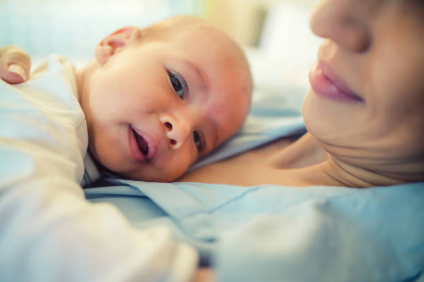 istock Mother with baby on bed having good time 1182837412