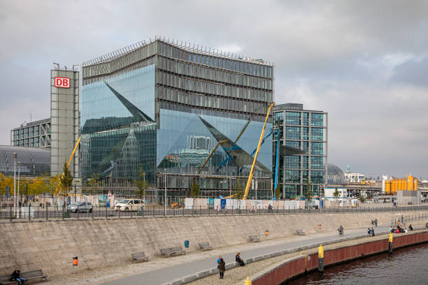 Berlin, Germany - April 16, 2025: Modern architecture of Berlin Hauptbahnhof with glass facade. Busy transportation hub with taxis and pedestrians at daytime.