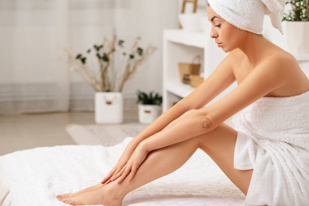 istock woman applying cream on her legs 1182843951