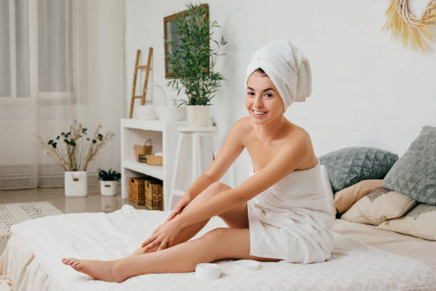 istock woman applying cream on her legs 1182843971