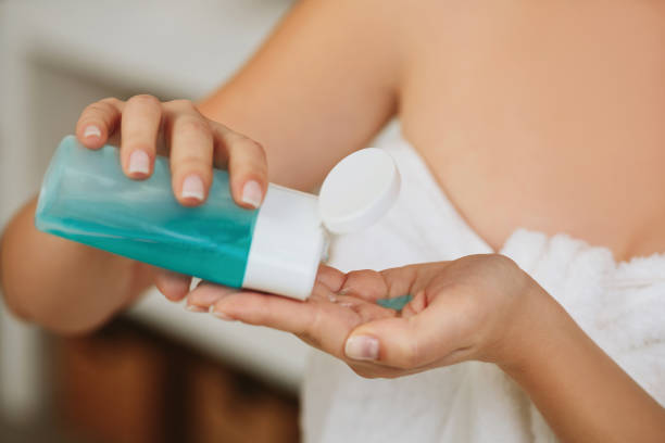 istock women's hands hold tonic to remove makeup. 1182844082