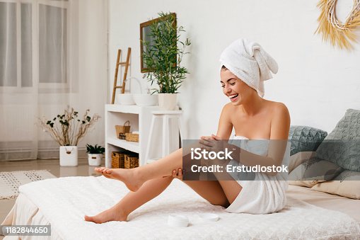 istock woman applying cream on her legs 1182844650