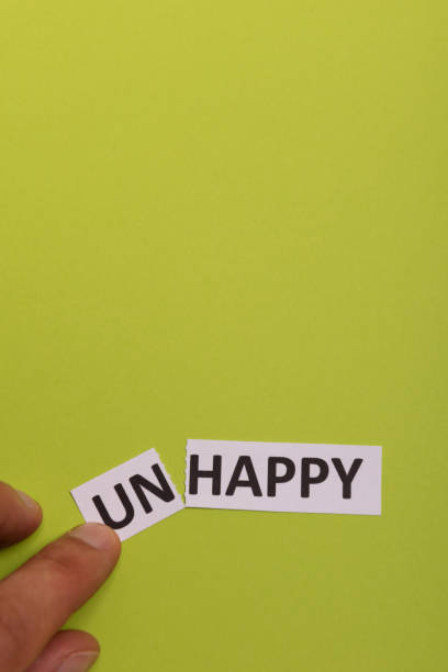 istock man hand holding card with text unhappy, cutting word 'un' so it written 'happy'. Copy space. Lime background. Studio shoot 1182845031
