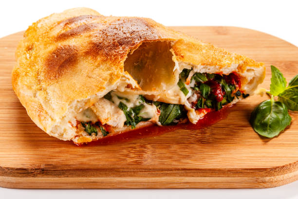 istock Calzone Pizza on cutting board on white background 1182847513