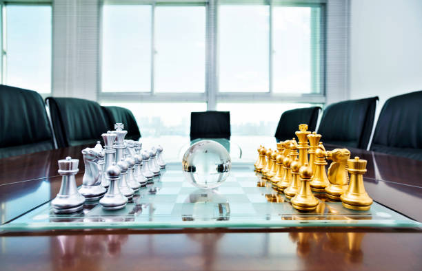 istock Chess pieces and glass earth globe on the conference table 1182848832