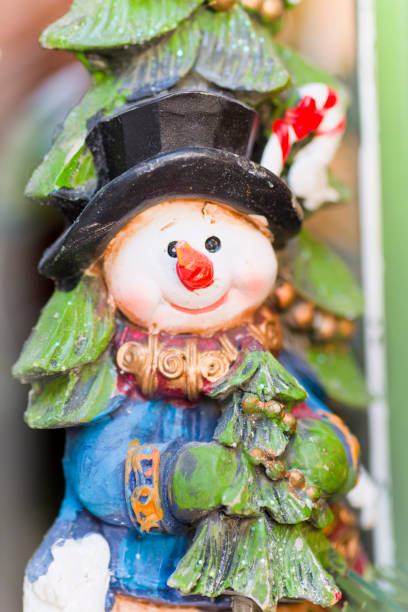 istock Snowman holding a small Christmas tree 1182849073